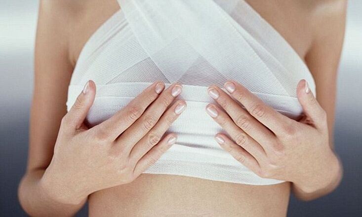 Breasts are bandaged after breast augmentation surgery
